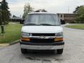 A white 2004 Chevrolet Express van facing forward with a black grille and the Chevrolet emblem prominently displayed