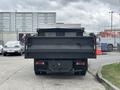 A 2015 Mitsubishi Fuso FE160 truck viewed from the rear featuring a flatbed and tailgate design with a cargo area ready for loading
