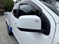 A white 2017 Chevrolet Colorado with a black side mirror featuring a small light indicator on the front