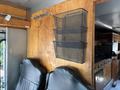A 2008 Workhorse W62 with black mesh storage baskets mounted on a wooden wall and two black leather seats in the foreground
