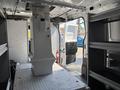 A 2019 Ford Transit 350 interior view showcasing a spacious cargo area with shelves and a central divider for storage