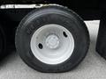 A close-up of a Goodyear tire mounted on a white wheel for a 2011 International 4400 truck with a textured black tread