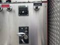 A control panel with various levers and buttons labeled for operating instructions and a tank to pump feature on a 2002 GMC C7500 fire truck