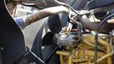 A close-up view of the engine components of a 2003 International 5600i featuring exposed pipes belts and a fan assembly