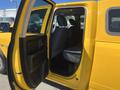 A 2015 RAM 1500 truck with a yellow exterior featuring a wide open passenger door showcasing the interior seats and cabin