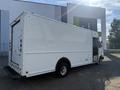 A white 2012 Ford Econoline delivery van with a closed rear door and the logo visible on the side