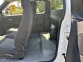Interior view of a 2011 Chevrolet Colorado showing the front seats with fabric upholstery and the grey floor space between them