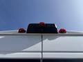 The rearview of a 2022 RAM Promaster 350 showing a black roof-mounted light fixture with three red brake lights
