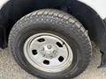 Close-up of a 2016 RAM 1500 tire featuring a rugged tread pattern and a silver alloy wheel with five lug nuts