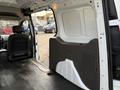 Interior view of a 2020 Ford Transit Connect showing a spacious cargo area with a molded wall panel and a single seat visible in the foreground