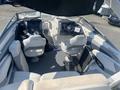 Interior of a 2013 Larson 238 boat featuring two captain's chairs and a spacious seating area with a steering wheel and dashboard visible in the center