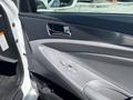 Interior door panel of a 2014 Hyundai Sonata with window control buttons and a sleek design in gray and silver tones