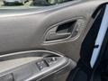 Interior door panel of a 2017 Chevrolet Colorado featuring a handle power window controls and textured black material