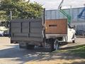 A 2014 RAM 5500 flatbed truck with a wooden side and rear panel parked with the tailgate down