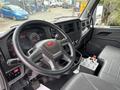 Interior of a 2025 Peterbilt 536 featuring a steering wheel dashboard and controls with a small decorative figure on the console