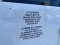 A 2020 Chevrolet Express with a sign attached detailing instructions for lift activation including steps for key switch and door operation