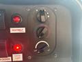 Dashboard controls of a 2012 Ford E-450 featuring knobs and indicator lights for seatbelt, door alert, and climate settings