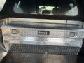 A silver diamond plate tool box with the label TRAILFX in a Ford F-150 truck bed