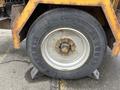 A close-up of a 2015 Vermeer Corporation BC1200XL tire mounted on a wheel with visible wear and dirt