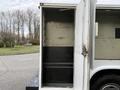 A 2017 Ford F-350 SD with a white service body featuring an open storage compartment and a black interior shelf