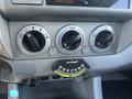 The interior control panel of a 2010 Toyota Tacoma featuring three circular knobs for temperature and airflow settings and a gauge for level indication
