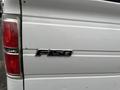 A 2013 Ford F-150 with a silver exterior featuring a prominent F-150 badge on the tailgate and red taillights