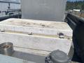 A 2010 aluminum 16 foot boat with a slightly dirty cooler resting on the deck and a metal container nearby