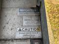 A metal lift platform with several warning and instruction labels including maximum capacity of 3000 pounds and a caution to stand clear of the platform area