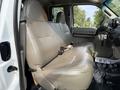 A light gray vinyl bench seat in the cabin of a 2008 Ford F-450 SD with seatbelts visible and no occupants
