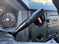 A close-up of the steering column of a 2017 Ford F-650 Super Duty featuring a gear shift lever with plus and minus buttons