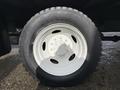 Close-up of a white wheel and tire from a 2014 International TerraStar featuring a six-stud hub design and deep tread pattern