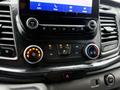 Interior dashboard of a 2020 Ford Transit featuring climate control dials and touchscreen display for audio and phone settings