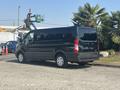 A 2016 Ford Transit 150 full-size van in black with multiple side windows and rear doors parked on a driveway