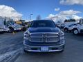 A 2017 RAM 1500 pickup truck with a silver grille and chrome accents is parked in the foreground facing the camera