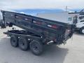 A 2014 PJ 16 foot dump trailer featuring a black metal body and three axles with visible mud on the tires