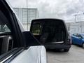 Reflective side mirror of a 2017 Chevrolet Silverado 1500 showing a view of parked vehicles and trees