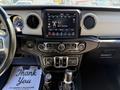 Interior dashboard of a 2021 Jeep Gladiator featuring a touchscreen display climate controls and gear shifters