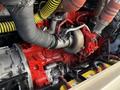 Close-up of a 2016 Grande West Vicinity engine showcasing a red turbocharger with yellow tubing and various connected hoses and components
