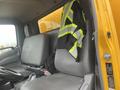 A 2019 Hino 155 truck's interior with gray seats and a safety vest with reflective stripes hanging from the driver's seat