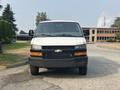 2021 Chevrolet Express van facing forward with a white exterior and a black grille
