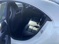Interior view of a 2014 Mercedes-Benz CLA-Class showing black leather rear seats and door panels