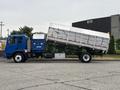 A blue 2017 Autocar Xpert truck with a raised dump bed and a blue storage unit attached to the chassis