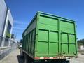 A green 1997 Freightliner FL70 truck with a large cargo box and two rear doors