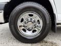 Close-up of the wheel of a 2004 Chevrolet Express featuring a shiny chrome rim and a black tire with visible tread and sidewall markings