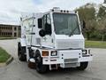 A white 2012 Global M4 street sweeper with a large front brush and multiple cleaning features parked on a pavement