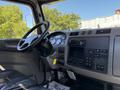 Interior view of a 2019 Peterbilt 337 truck featuring a steering wheel dashboard with gauges and control buttons along with a black leather driver's seat