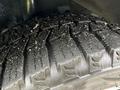 Close-up of a tire tread from a 2021 Kia Forte showing detailed patterns and texture with dirt and debris embedded in the grooves