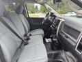 Interior of a 2016 RAM 1500 showing two front seats with gray upholstery and a console featuring controls and a touchscreen display