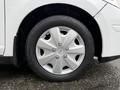 Close-up of a silver alloy wheel on a 2012 Nissan Versa showcasing five spokes and a central hub with the Nissan logo