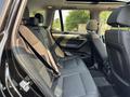 Interior view of the back seat of a 2013 BMW X3 featuring black upholstery and seat belts